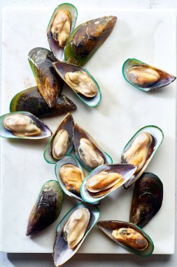 Mermer yüzeyinde çiğ kivi midyeleriyle üst görünüm