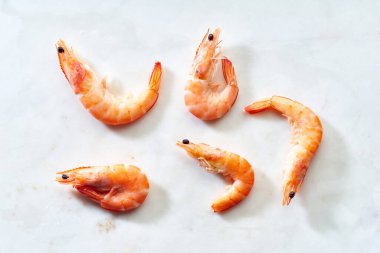 Beyaz zemin üzerinde büyük donmuş karideslerin üst görünümü