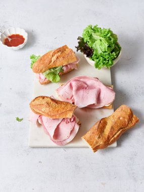 Taze yapılmış sandviçler ekmek, mozzarella peyniri, jambon ve marul ile hazırlandı..