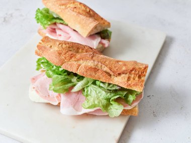 Baget, dilimlenmiş jambon, mozzarella ve taze maruldan yapılmış iki sandviç..