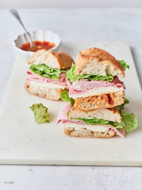 Masada baget, mozarella peyniri, jambon ve maruldan yapılmış sağlıklı bir sandviç bulunur..