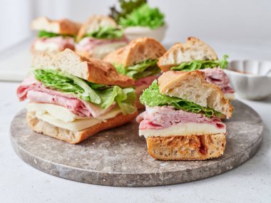 Ekmek, mozzarella peyniri, marul ve jambondan yapılmış sağlıklı sandviçlere odaklanın..