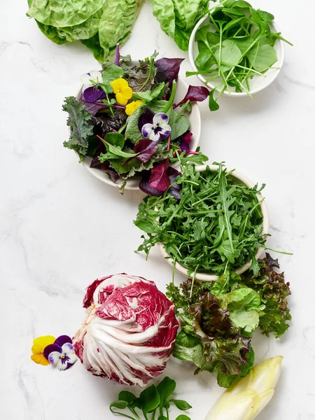 Romaine ve radicchio gibi taze marullar mermer tezgahta sergilenir. Kar bezelyeleri ve yenilebilir çiçekler renk katar. Bu kurum vejetaryen yemek fikirlerini ve sağlıklı yemek yemeyi teşvik ediyor..