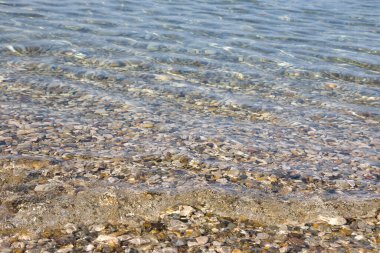Adriyatik Denizi 'nin yüzeyinde bir çakıl taşı kumsalında küçük bir dalga