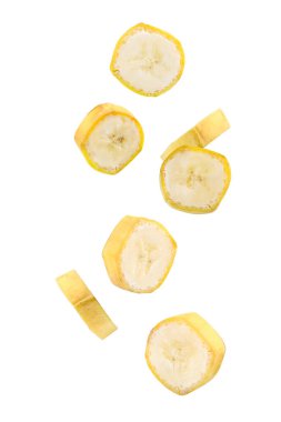 Uçan taze olgun muz dilimleri beyaz arka planda izole edilmiş.