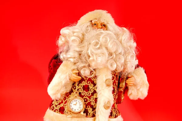 Noel Baba kırmızı arka planda bir saat tutuyor