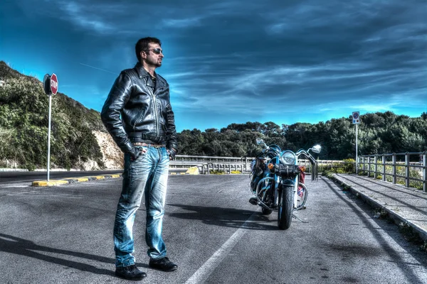 Motociclista de pé ao lado de uma motocicleta clássica — Fotografia de Stock