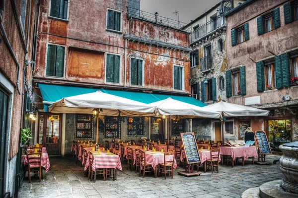 Mesas de restaurante e chiairs em uma pequena praça — Fotografia de Stock