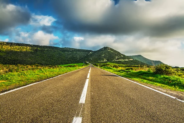 Estrada país sob enormes nuvens — Fotografia de Stock