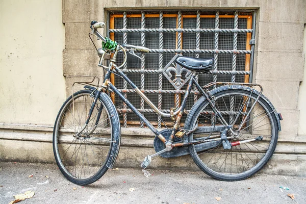 Oude fiets tegen een rustieke muur — Stockfoto