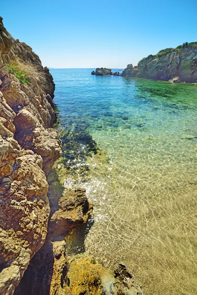 Riva rocciosa e acqua cristallina — Foto Stock