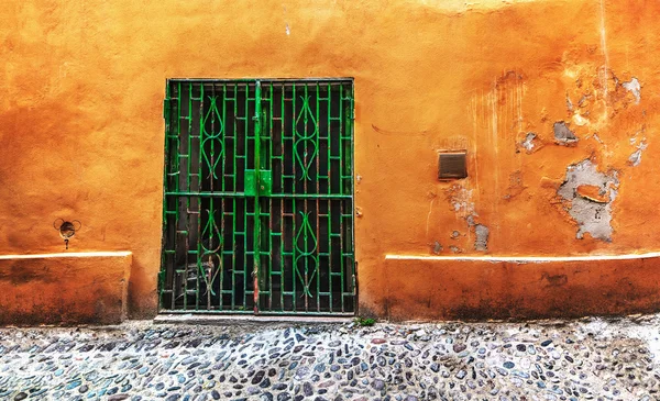 Groene poort in een oranje muur — Stockfoto