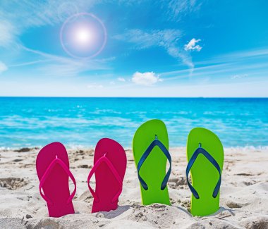 kum üzerinde renkli flip flop