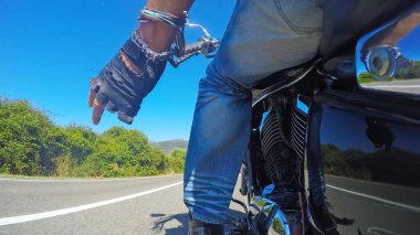 Motorcu bir ülke yolda sürme sırasında selamlıyor