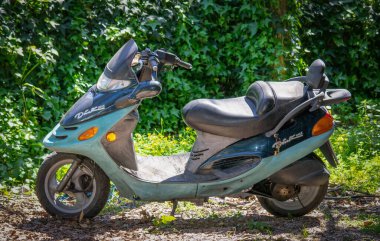 Sassari, Ita - 17 Nisan 2013: Güneşli bir günde eski scooter yeşil bir bahçeye park edildi