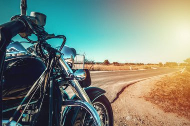 Bir kır yolunun kenarına park edilmiş klasik bir motosiklet. Sardunya, İtalya