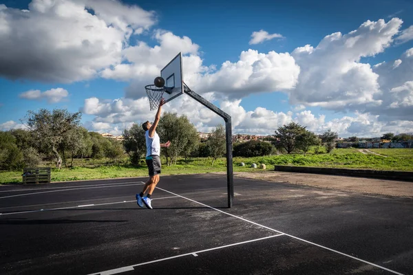 Man Skjuter Bollen Basketplan Molnig Himmel — Stockfoto