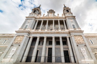 Bulutlu bir gökyüzünün altındaki Almudena katedralinin ön görüntüsü. Madrid, İspanya