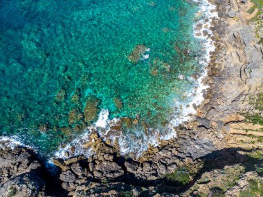 Alghero kıyılarındaki kayaların ve temiz suyun havadan görüntüsü. Sardunya, İtalya