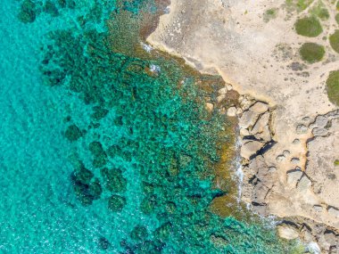 Alghero sahilindeki kayaların ve turkuaz suyun havadan görüntüsü. Sardunya, İtalya
