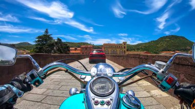 Classic motorcycle on an old bridge in Bosa on a spring day. Sardinia, Italy