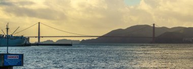 World famous Golden Gate bridge in San Francisco under a cloudy sky at dusk. California, USA