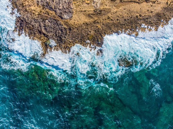 Blue sea and white waves by Alghero rocky shore. Sardinia, Italy