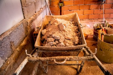 İnşaat alanında el arabası alçı dolu.