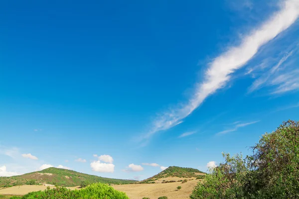 Zielone wzgórza i błękitne niebo z chmurami w słoneczny dzień — Zdjęcie stockowe
