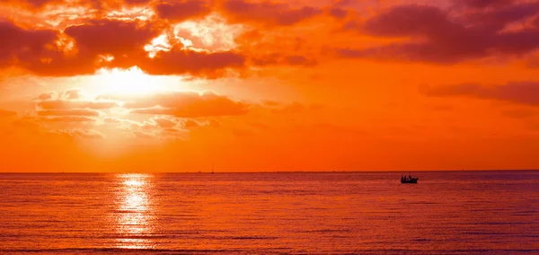 Silhouette bateau dans un coucher de soleil orange — Photo