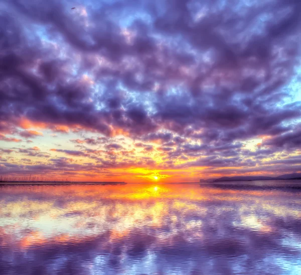 Kleurrijke zonsondergang weerspiegeld in het water — Stockfoto
