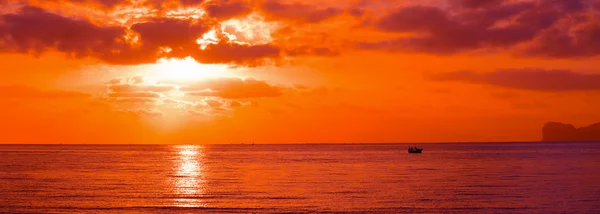 Båt silhuett i en orange solnedgång — Stockfoto