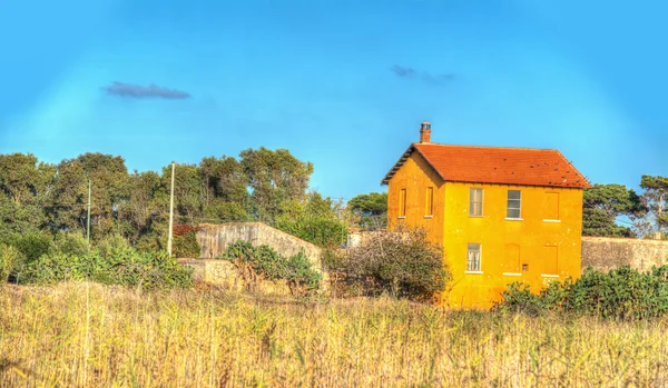 Casa de campo abaixo de um céu azul — Fotografia de Stock