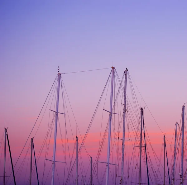 Mastros de barco sob um pôr-do-sol rosa e laranja — Fotografia de Stock