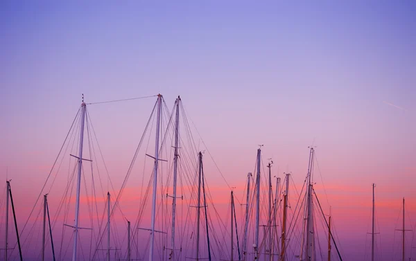 Mâts de bateau sous un coucher de soleil rose et orange — Photo