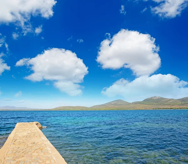 Rocky pier under soft clouds — Stock Photo, Image