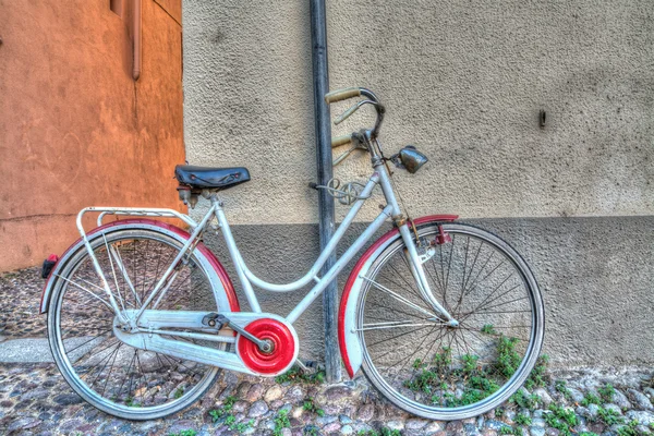 Röda och vita cykel mot väggen — Stockfoto