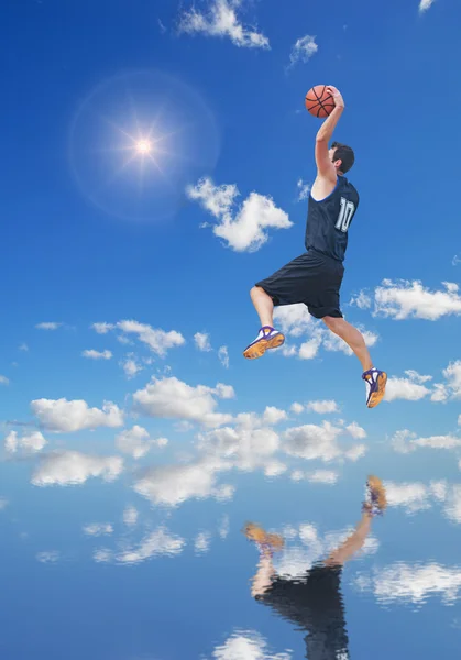 Basketballspieler in der Sonne, die sich im Wasser spiegelt — Stockfoto