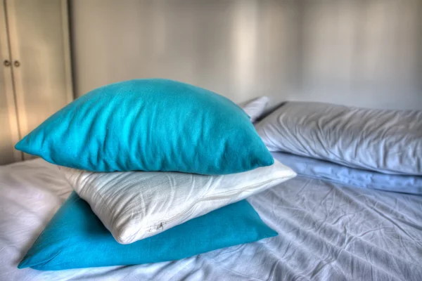 blue and white pillows on bed