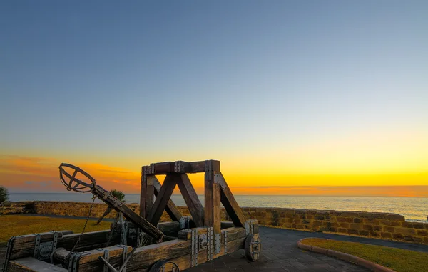 Catapulta antigua junto al paseo marítimo de Alghero al atardecer — Foto de Stock