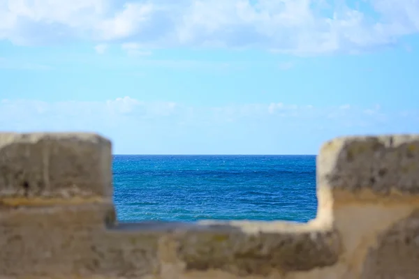 Bakstenen muur door de zee — Stockfoto