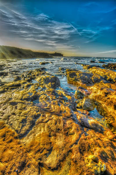 Rocas naranjas junto a la orilla de la playa de Porto Ferro — Foto de Stock