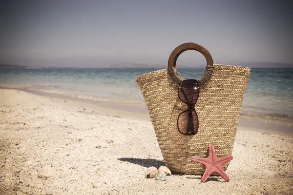 Straw bag with sunglasses and starfish — Stock Photo, Image