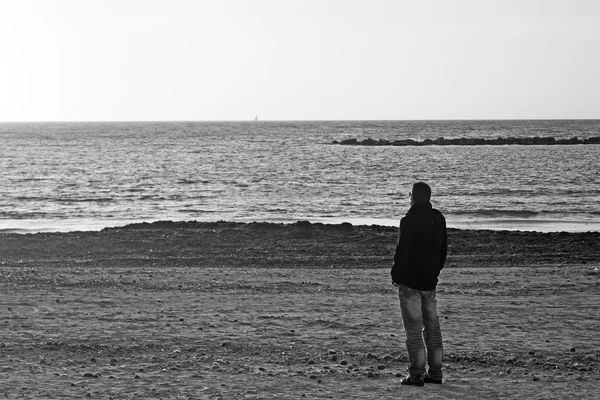 Uomo solo in spiaggia in inverno — Foto Stock