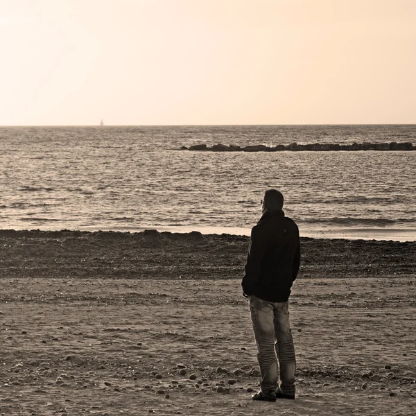 Uomo solo in spiaggia in tono seppia — Foto Stock