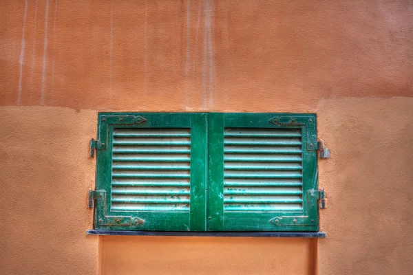 Litet fönster i en orange vägg — Stockfoto