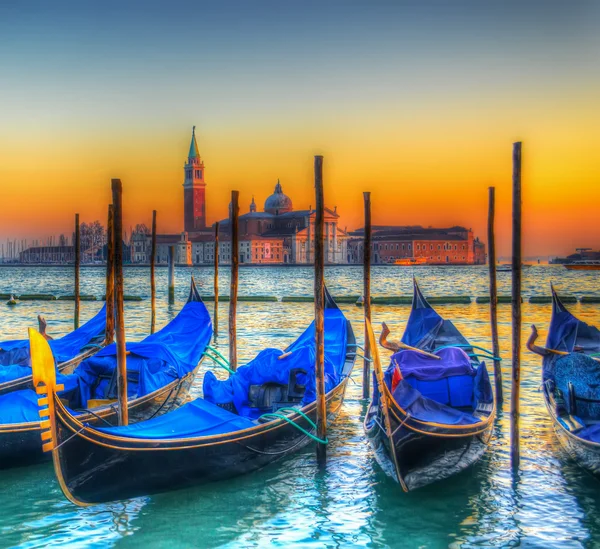 Blue gondolas under a colorful sunset — Stock Photo, Image