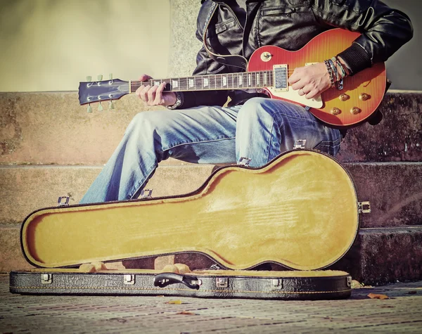 Guitarrista con estuche de guitarra abierto en tono vintage —  Fotos de Stock