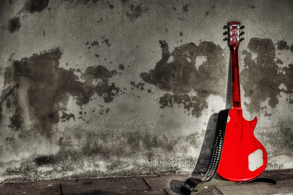 Gitara elektryczna oparł się na rustykalne ściany w selektywnej desaturatio — Zdjęcie stockowe
