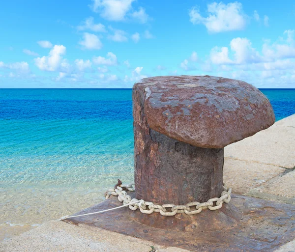 Rusty bollard by the shore — Stock Photo, Image